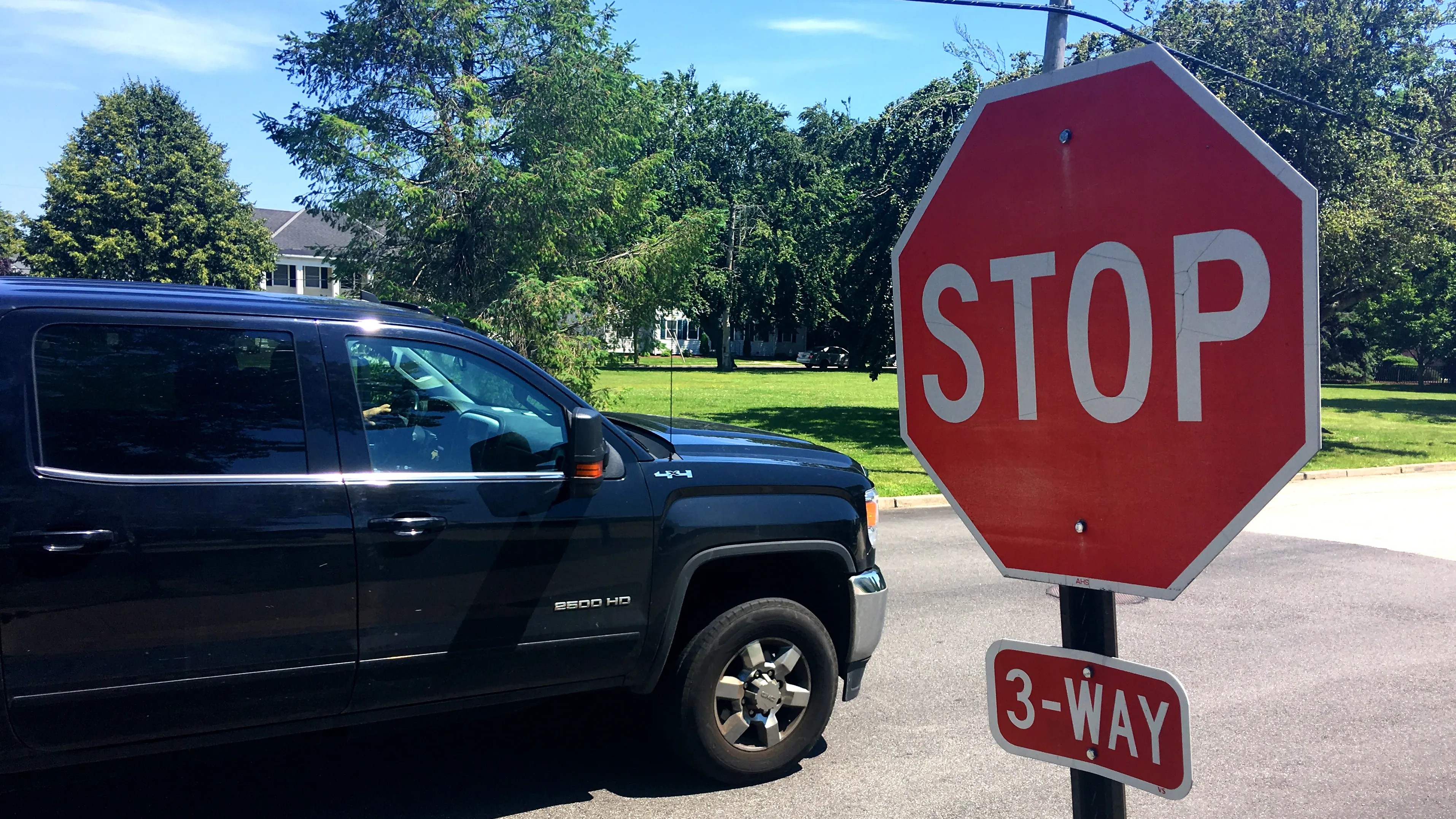 STOP sign with a 3-WAY plaque next to a pickup truck stopped at the intersection