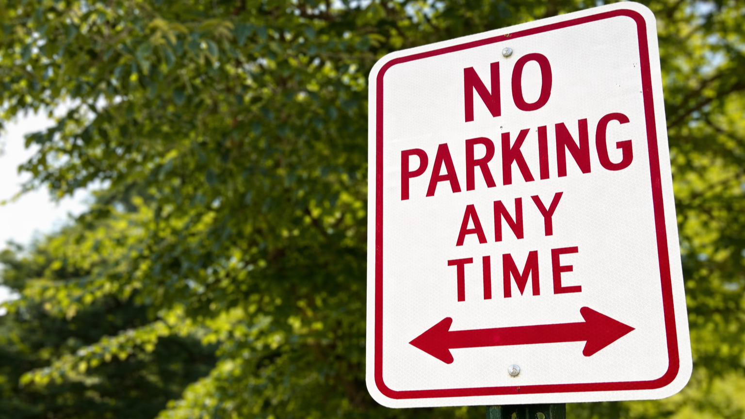 Close-up of a red and white NO PARKING ANY TIME sign