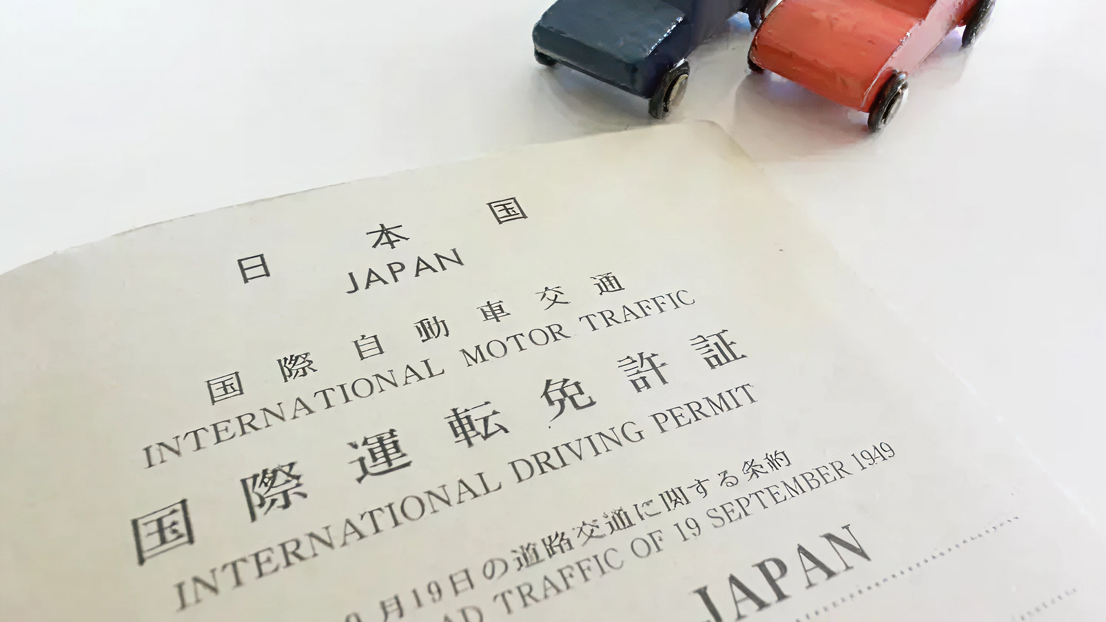 国際運転免許証の冊子とミニカーのおもちゃ